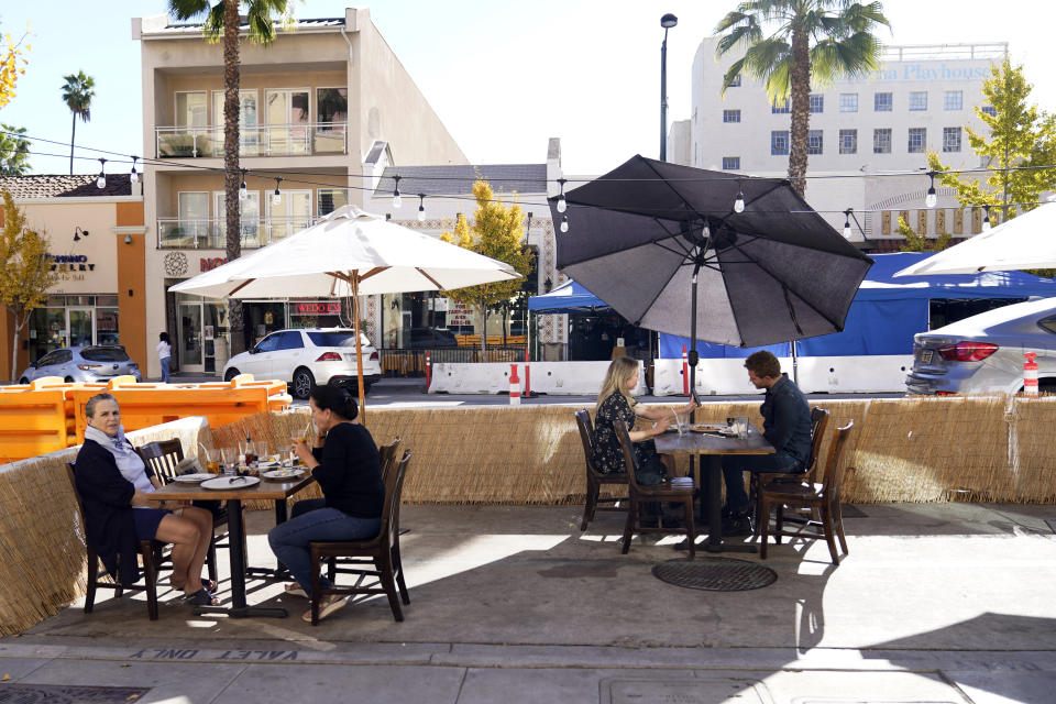 *** Hold For Story *** Patrons eat lunch outside of Settebello Pizzeria Napoletana Tuesday, Dec. 1, 2020, in Pasadena, Calif. Pasadena has become an island in the center of the nation's most populous county, where a surge of COVID-19 cases last week led to a three-week end to outdoor dining and California's first stay-home order since the pandemic began to spread across the state in March. (AP Photo/Marcio Jose Sanchez)