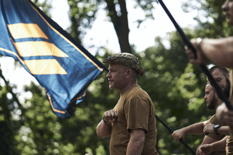 Soldiers of Ukraine's 3rd Separate Assault Brigade shout slogans as they stand in line, near Bakhmut, the site of fierce battles with the Russian forces in the Donetsk region, Ukraine, Sunday, Sept. 3, 2023. (AP Photo/Libkos)