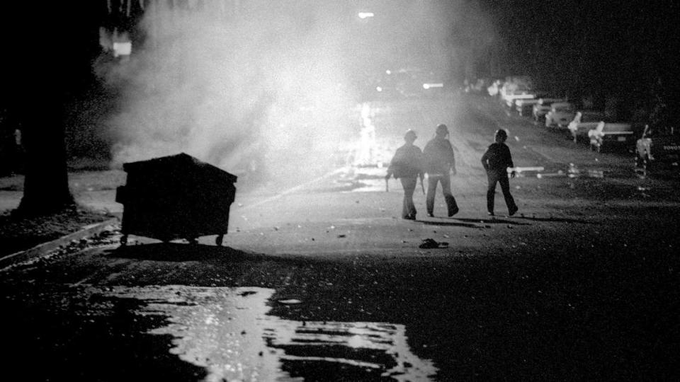 Early Sunday morning, sheriff’s deputies patrol California Boulevard near a smoldering dumpster that was set ablaze by rioters during the 1990 Poly Royal riots.