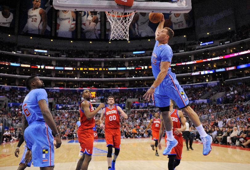 Los Angeles Clippers forward Blake Griffin, right, goes up for a dunks as teammate center DeAndre Jordan, left, stands near along with Philadelphia 76ers guard Hollis Thompson, second from left, and center Spencer Hawes, third from left, during the first half of an NBA basketball game, Sunday, Feb. 9, 2014, in Los Angeles. (AP Photo/Mark J. Terrill)