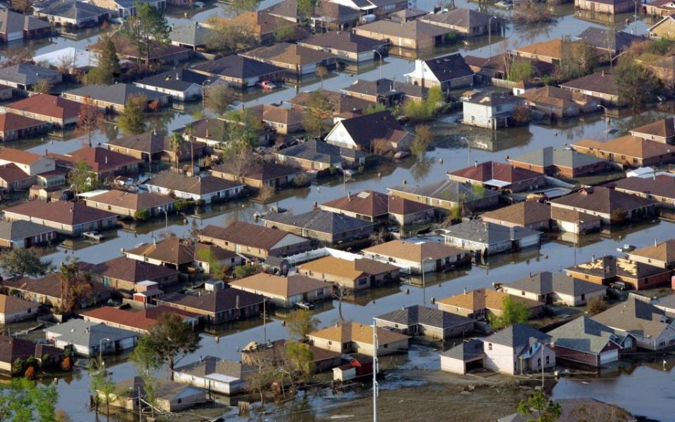 Neighborhoods are flooded with oil and water two weeks after Hurricane on September 12, 2005 in New Orleans, Louisiana. (Photo by Carlos Barria-POOL/Getty Images)