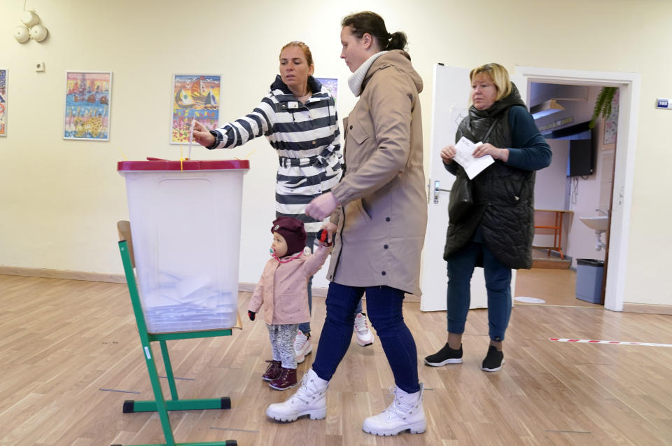 Latvians cast their ballots at a polling station during general elections, in Riga, Latvia, Saturday, Oct. 1, 2022. Polling stations opened Saturday in Latvia for a general election influenced by neighboring Russia’s attack on Ukraine, disintegration among the Baltic country’s sizable ethnic-Russian minority and the economy, particularly high energy prices. (AP Photo/Roman Koksarov)