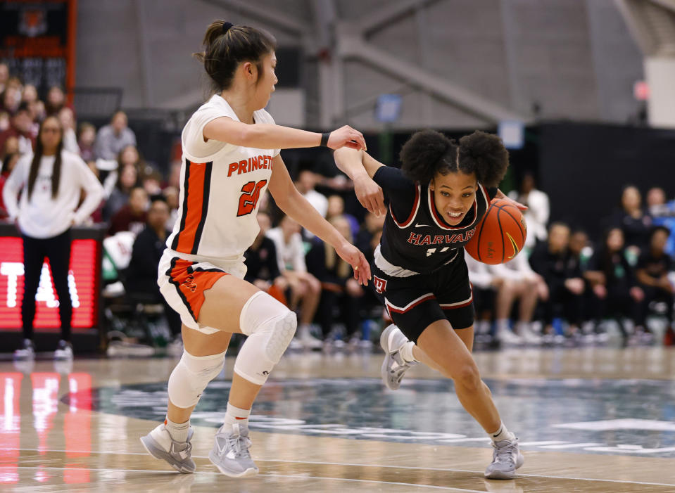 Harvard guard Harmoni Turner, right, drives to the basket against Princeton guard Kaitlyn Chen during the first half of the Ivy League championship NCAA college basketball game, Saturday, March 11, 2023, in Princeton, N.J. (AP Photo/Noah K. Murray)