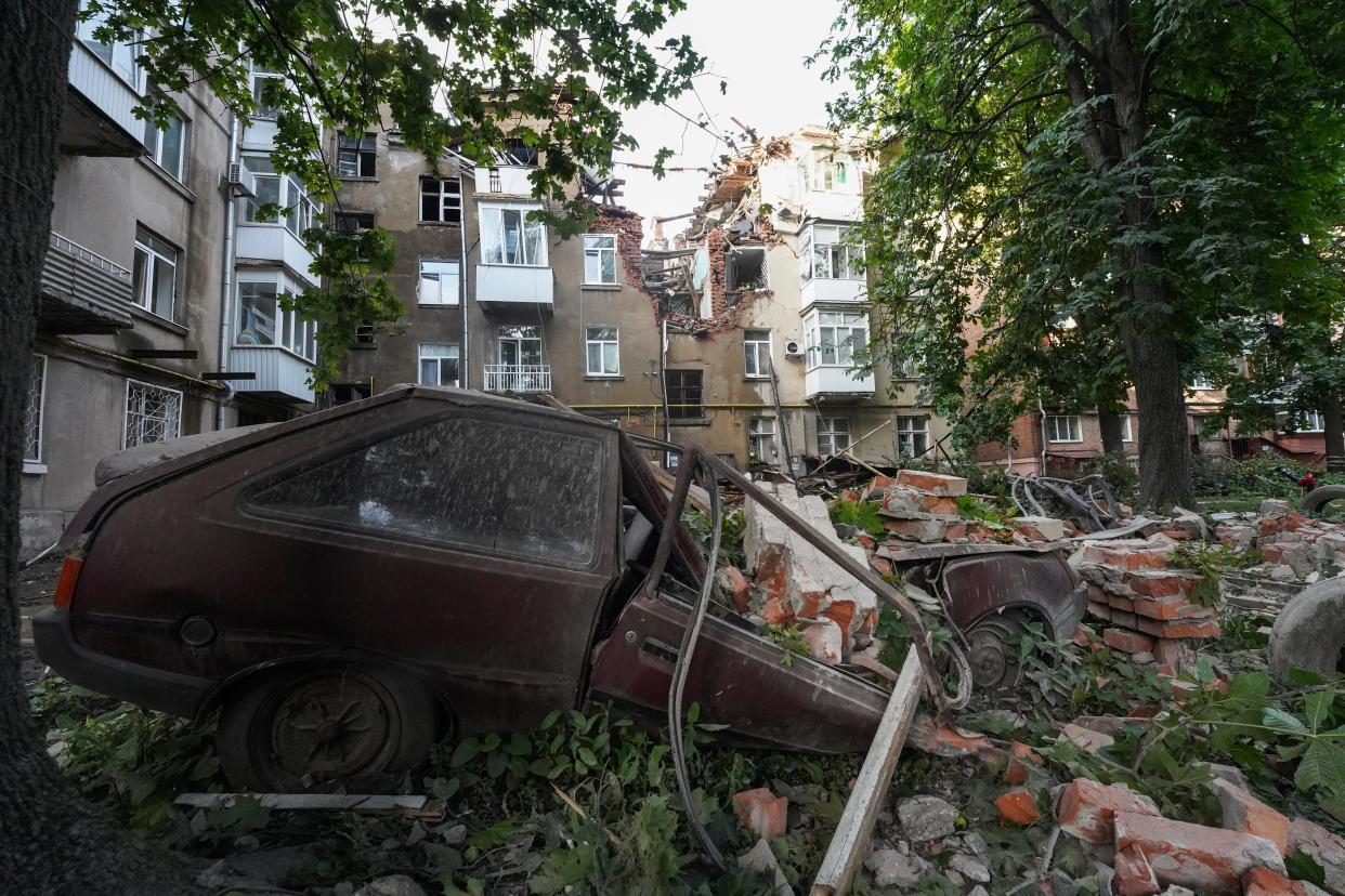 Damages on a car and an apartment building are seen after a Russian attack at a residential area in Sumy (AP)