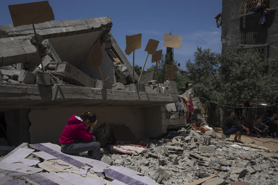 Jalal Nabhan and relatives sit in front of the ruins of their home, which was destroyed in an Israeli airstrike, in Jabaliya, northern Gaza Strip, Sunday, May 14, 2023. The airstrike left 42 members of the extended family homeless. It also left four children with special needs without their wheelchairs, crutches and medical equipment needed to move about. Israel says the building was used as a command center by the Islamic Jihad militant group. The two sides reached a cease-fire Saturday to end five days of fighting. (AP Photo/Fatima Shbair)