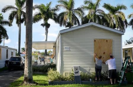FILE PHOTO: Yana and Jeremy Cauble board up their mobile home in preparation for Hurricane Irma in Homestead, Florida, U.S., September 7, 2017. REUTERS/Bryan Woolston/File Photo