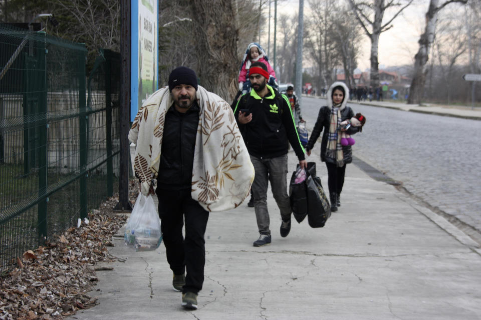 Migrants walk to the border gate of Pazarkule in Edirne, near Turkey-Greece border, early Friday, Feb. 28, 2020. An air strike by Syrian government forces killed scores of Turkish soldiers in northeast Syria, a Turkish official said Friday, marking the largest death toll for Turkey in a single day since it first intervened in Syria in 2016. (AP Photo/Ergin Yildiz)