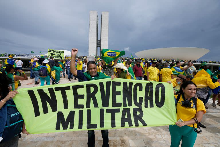 Seguidores del ex Presidente Jair Bolsonaro sostienen un cartel que dice "Intervención Militar!".