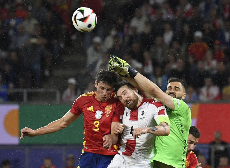 Los georgianos Giorgi Mamardashvili y Guram Kashia disputan el balón cojn el español Robin Le Normand, en el partido entre las selecciones de España y Georgia por los octavos de final de la Euro 2024, en el Cologne Stadium, Colonia, Alemania