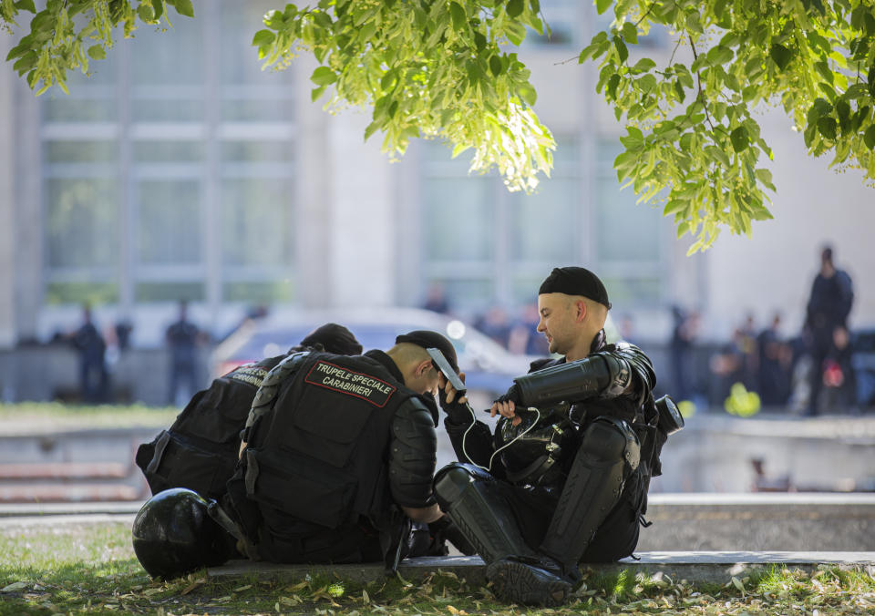 Riot policemen sit in the shade outside the presidency headquarters in Chisinau, Moldova, Wednesday, June 12, 2019. Moldova's police chief on Wednesday dismissed six officers who publicly backed a rival government, reflecting a continuing power struggle that has heightened political tensions in the impoverished ex-Soviet nation.(AP Photo/Roveliu Buga)