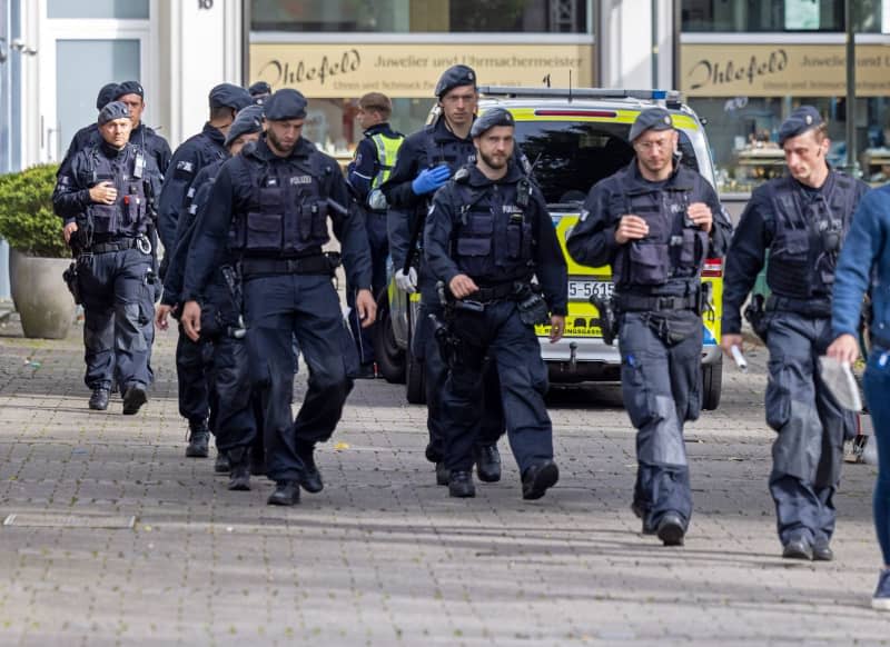 Police officers walk past the scene of a knife attack at the Solingen town festival. Several people were killed and injured in a knife attack on Friday evening at the city festival celebrating the 650th birthday of the city of Solingen. Thomas Banneyer/dpa