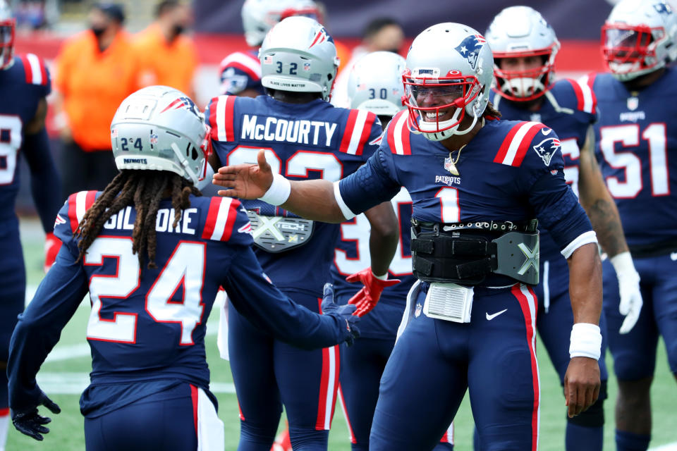 Stephon Gilmore prepares to shake hands with Cam Newton during a game. 