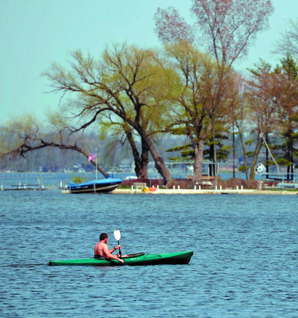 A kayaker paddles around Nagawicka Lake in the 80 degree weather in 2013.