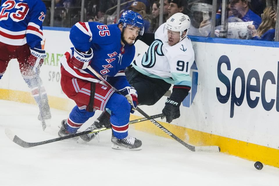 New York Rangers' Ryan Lindgren (55) fights for control of the puck with Seattle Kraken's Daniel Sprong (91) during the third period of an NHL hockey game Friday, Feb. 10, 2023, in New York. (AP Photo/Frank Franklin II)