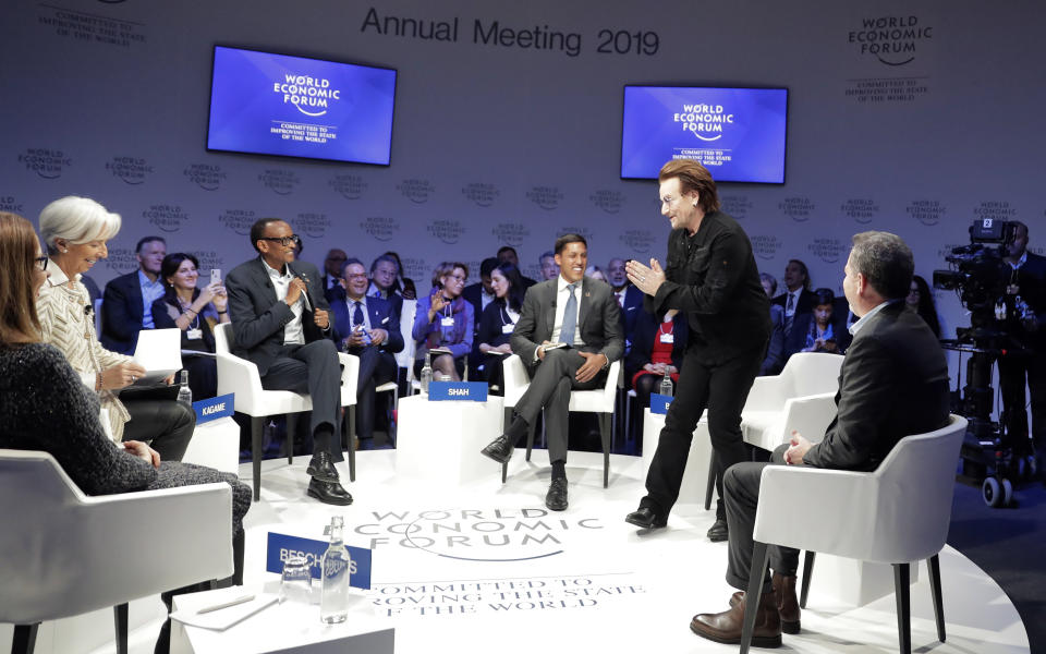 Singer and co-founder of RED Bono, 2nd right, gestures to Afsaneh Mashayekhi Beschloss, founder of RockCreek, Christine Lagarde, Managing Director of IMF and Rwanda President Paul Kagame, from left, as he arrives for the "Closing the Financing Gap" session at the annual meeting of the World Economic Forum in Davos, Switzerland, Wednesday, Jan. 23, 2019. (AP Photo/Markus Schreiber)