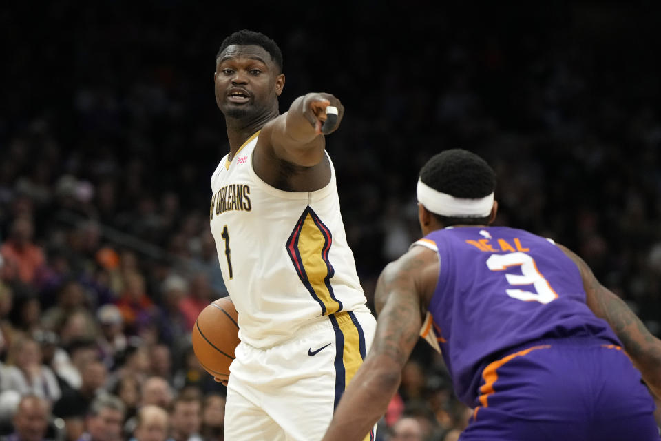 New Orleans Pelicans forward Zion Williamson, left, points to a teammate in front of Phoenix Suns guard Bradley Beal (3) during the first half of an NBA basketball game, Sunday, April 7, 2024, in Phoenix. (AP Photo/Rick Scuteri)