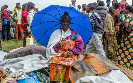 A refugee from the Democratic Republic of Congo sits with her belongings near the United Nations High Commissioner for Refugees (UNHCR) offices in Kiziba refugee camp in Karongi District, Rwanda February 21, 2018. REUTERS/Jean Bizimana