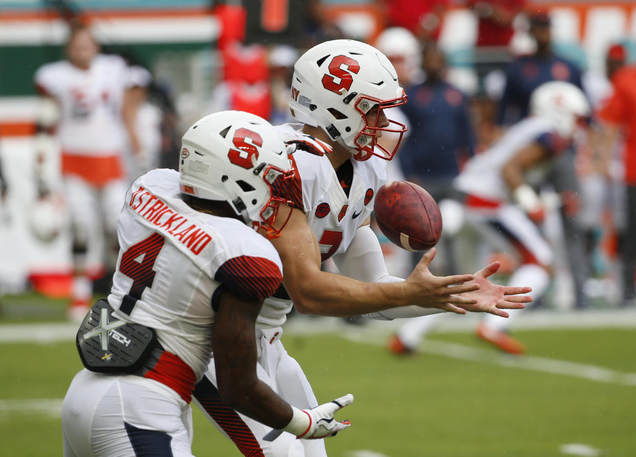 Syracuse quarterback Eric Dungey (2) bobbles the snap as he fakes a handoff to running back Dontae Strickland (4) during the first half of an NCAA College football game against Miami, Saturday, Oct. 21, 2017 in Miami Gardens, Fla. (AP Photo/Wilfredo Lee)