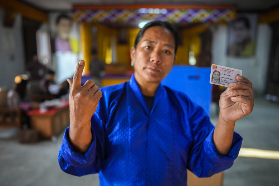 A Bhutanese woman shows the ink mark on her index finger after casting her vote in the national elections in Deothang, Bhutan, Tuesday, Jan. 9, 2024. The landlocked country in the eastern Himalayan mountain range is electing a new Parliament, with the parties in contest promising to fix the nation’s economic crisis. (AP Photo/Anupam Nath)