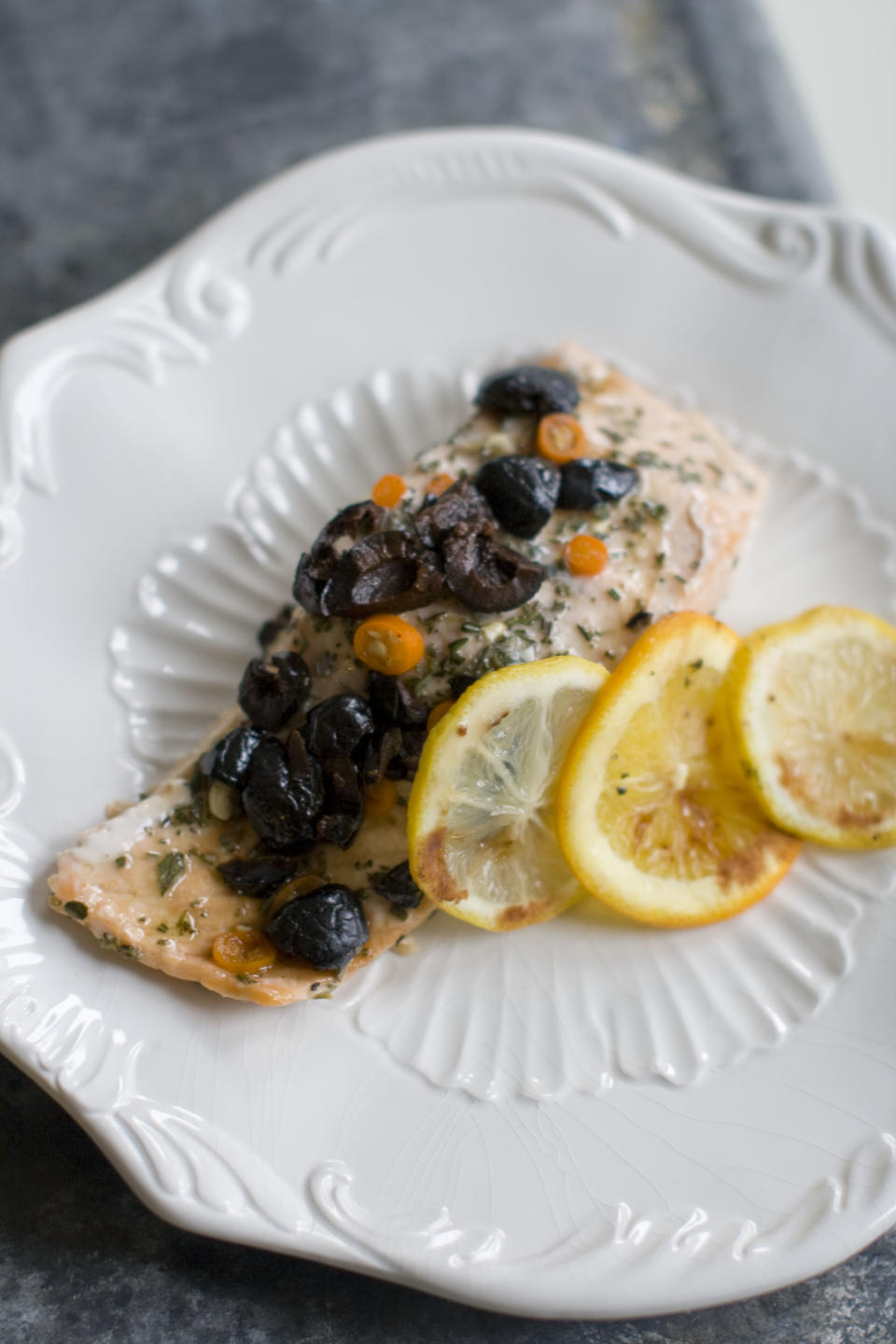 This Dec. 2, 2013 photo shows salmon that has been baked in a bag with citrus, olive and chilies in Concord, N.H. The bag keeps the flavor and moisture trapped inside during cooking, allowing the juices from the fish and the other ingredients to mingle and become a wonderful sauce. (AP Photo/Matthew Mead)