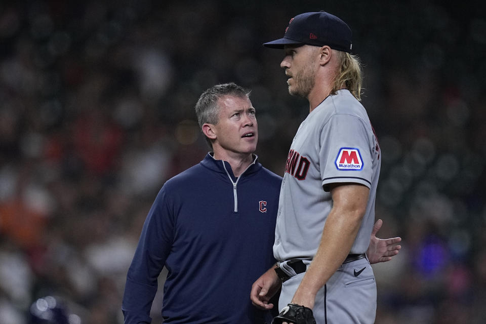 Cleveland Guardians starting pitcher Noah Syndergaard, right, talks with head athletic trainer James Quinlan, left, after being hit by a comebacker from Houston Astros' Jeremy Pena during the sixth inning of a baseball game, Monday, July 31, 2023, in Houston. (AP Photo/Kevin M. Cox)