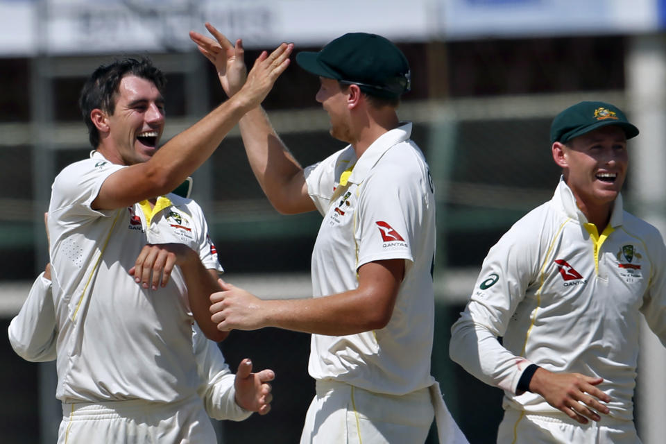 Australia's Pat Cummins, left, celebrates with teammates after taking the wicket Pakistan Mohammad Rizwan on the third day of the second test match between Pakistan and Australia at the National Stadium in Karachi, Pakistan, Monday, March 14, 2022. (AP Photo/Anjum Naveed)