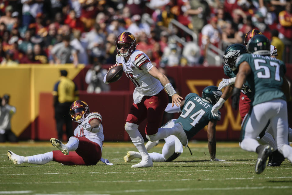 Washington Commanders quarterback Carson Wentz (11) scrambles during the first half of an NFL football game against the Philadelphia Eagles, Sunday, Sept. 25, 2022, in Landover, Md. (AP Photo/Nick Wass)