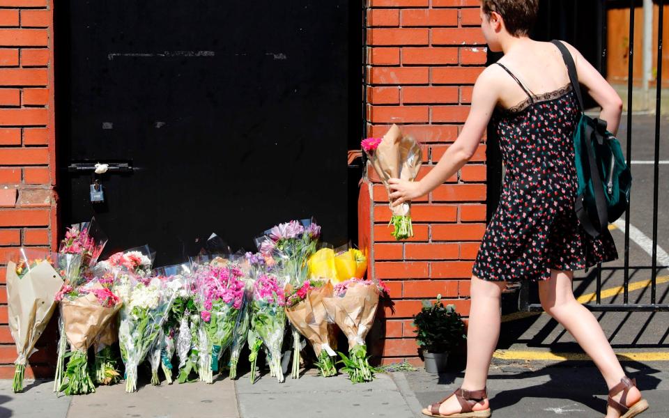 A woman lays flowers in tribute outside Finsbury Park Mosque - Credit: TOLGA AKMEN/AFP