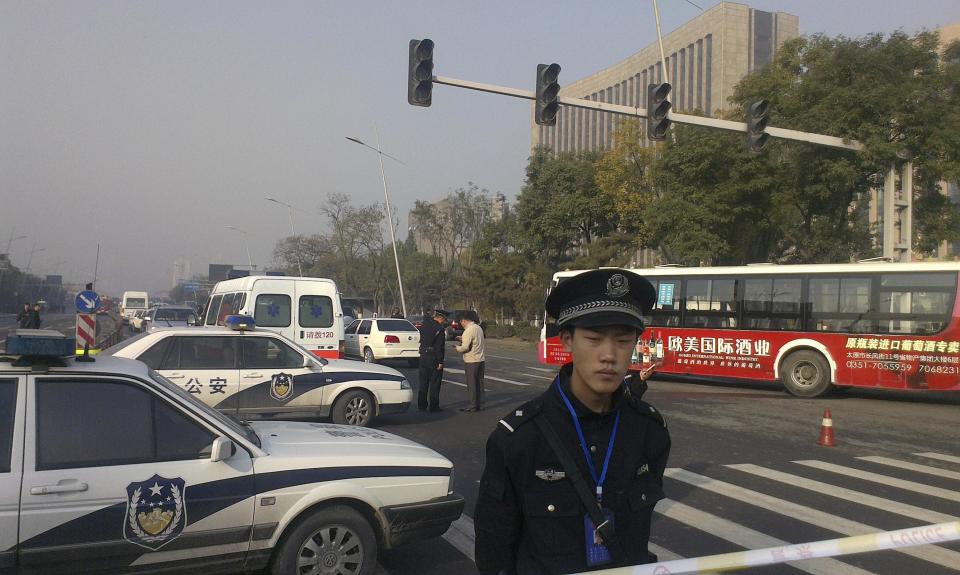 Police stand guard in front of the Shanxi Provincial Communist Party office building after explosions in Taiyuan