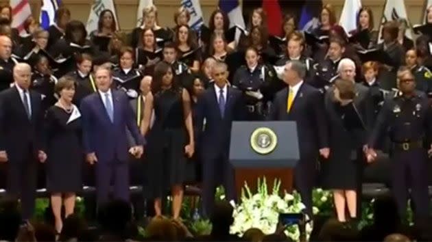 The former president held hands with wife Laura and first lady Michelle Obama. Source: News365/YouTube.