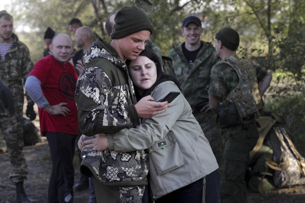 FILE - A Russian recruit and his wife embrace at a railway station in Prudboi, in Russia's Volgograd region, Thursday, Sept. 29, 2022. A campaign to replenish Russian troops in Ukraine with more soldiers appears to be underway again, with makeshift recruitment centers popping up in cities and towns, and state institutions posting ads promising cash bonuses and benefits to entice men to sign contracts enabling them to be sent into the battlefield. (AP Photo, File)