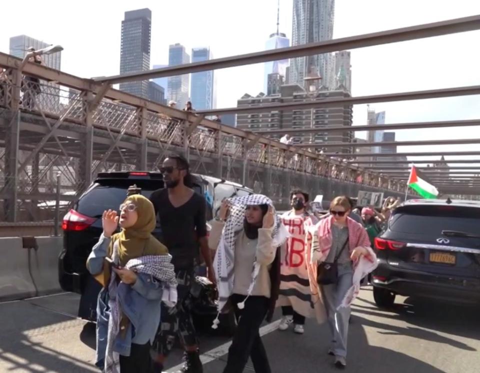 Protestors walking around cars on the Manhattan-bound side of the bridge. FNTV/Olga Fe