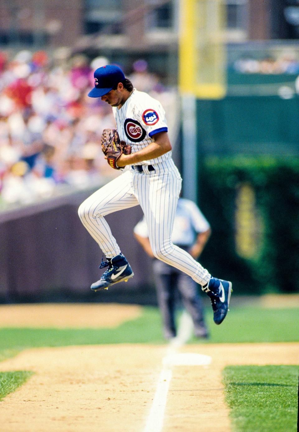 Former Iowa Cubs pitcher Turk Wendell jumps over the third-base line at Wrigley Field after finishing an inning for the Chicago Cubs.
