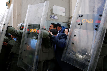 Venezuelan National Guards escort deputies and people as they walk out from the National Assembly after a session in Caracas, Venezuela October 27, 2016. REUTERS/Carlos Garcia Rawlins