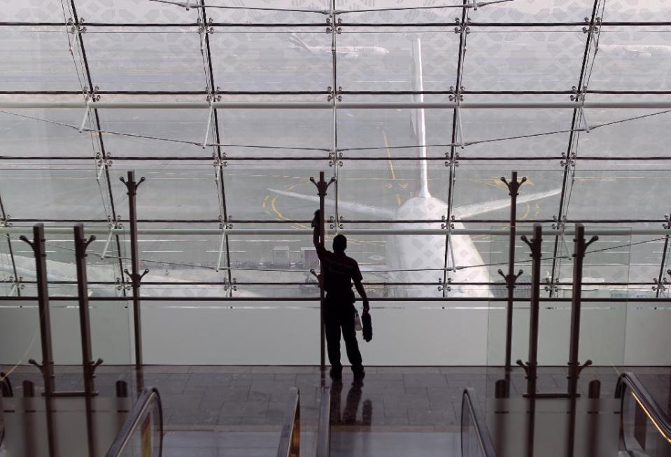 In this Sunday, Feb. 10, 2013, photo a laborer cleans a window at the new Concourse A of the Dubai airport in Dubai, United Arab Emirates. For generations, international fliers have stopped over in London, Paris and Amsterdam. Now, they increasingly switch planes in Dubai, Doha and Abu Dhabi, making this region the new crossroads of global travel. The switch is driven by both the airports and airlines, all backed by governments that see aviation as the way to make their countries bigger players in the global economy. (AP Photo/Kamran Jebreili)