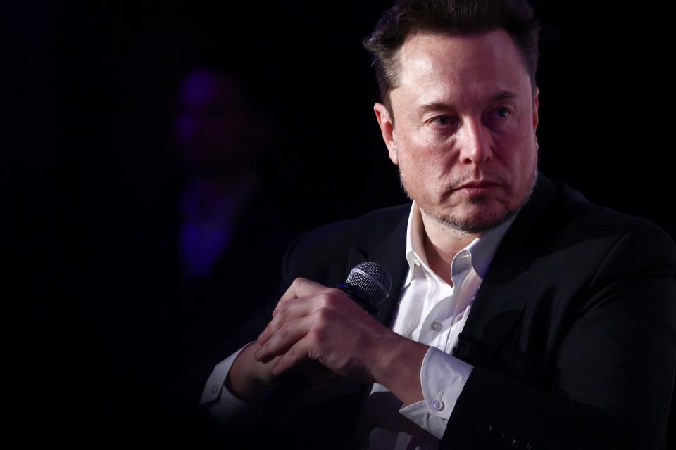 Elon Musk holding a microphone