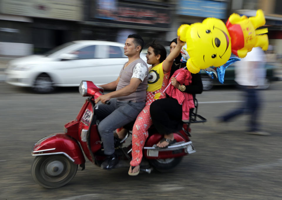 FILE - People ride a motorbike as they celebrate Eid al-Fitr feast, marking the end of the Muslim fasting month of Ramadan in Cairo, Egypt, Friday, July 17, 2015. (AP Photo/Amr Nabil, File)