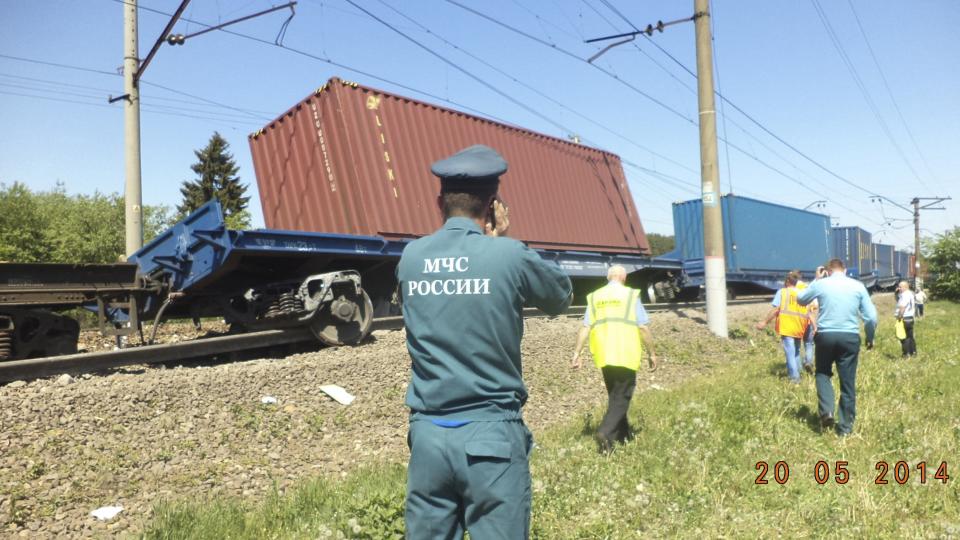 An Emergencies Ministry member speaks on a phone in front of a freight train after a collision with a passenger train in Moscow region in this May 20, 2014 picture provided by the Russian Emergencies Ministry. (REUTERS/Press Service of Russian Emergencies Ministry of Moscow Region)