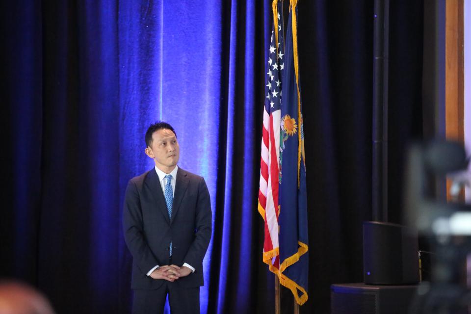 Kris Takamoto, executive vice president of Panasonic Energy, watches as a corporate promotional video plays at an economic development announcement event in Topeka.