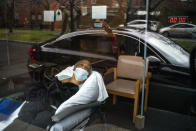 Family members, reflected in the window, wave goodbye to nursing home resident Barbara Farrior, 85, at the end of their visit at the Hebrew Home at Riverdale on Thanksgiving, Thursday, Nov. 26, 2020, in New York. The home offered drive-up visits for families of residents struggling with celebrating the holiday alone. (AP Photo/Eduardo Munoz Alvarez)