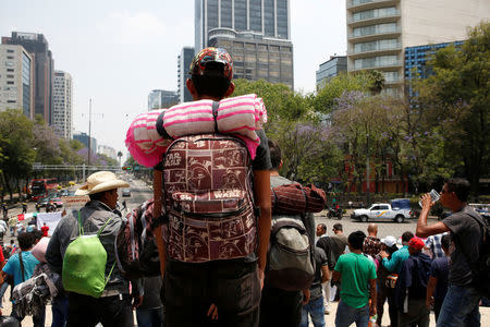 A Central American migrant, part of a caravan who drove through Mexico, takes part in a protest at the Angel of Independence monument in Mexico City, Mexico April 7, 2018. REUTERS/Ginnette Riquelme