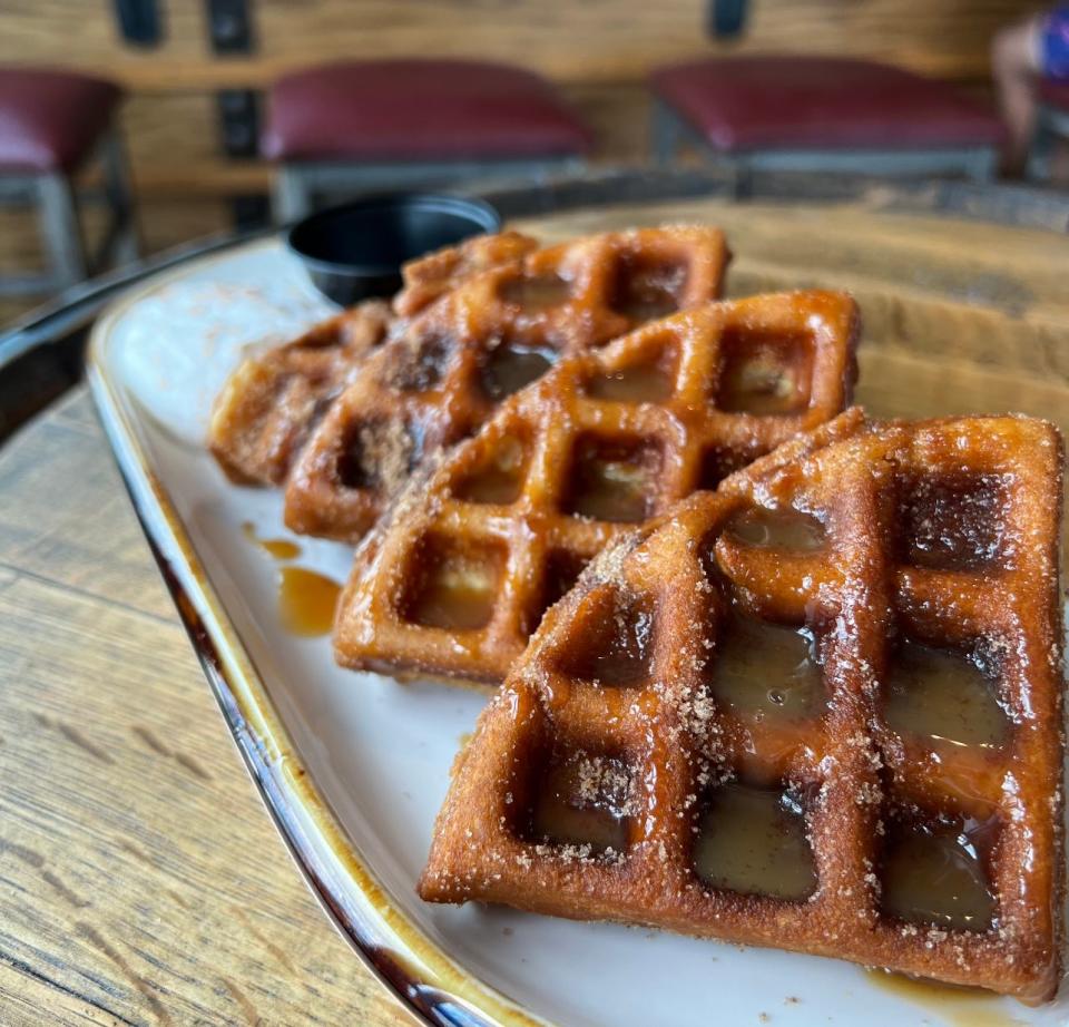 Homemade churro waffles drizzled with dulce de leche, found on the brunch menu at Half Moon in Keansburg.