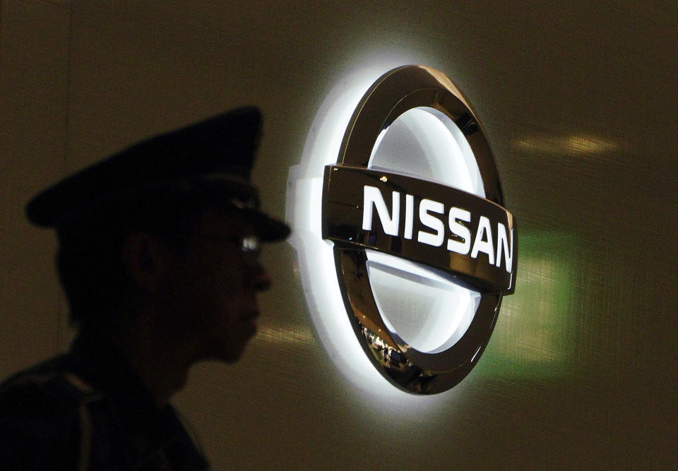 Un guardia de seguridad aparece junto al logo de Nissan Motor Co. en la sede global de la empresa en Yokohama, Japón, jueves 22 de noviembre de 2018. Nissan informó el despido de su presidente Carlos Ghosn, acusado de delitos financieros. (AP Foto/Eugene Hoshiko)