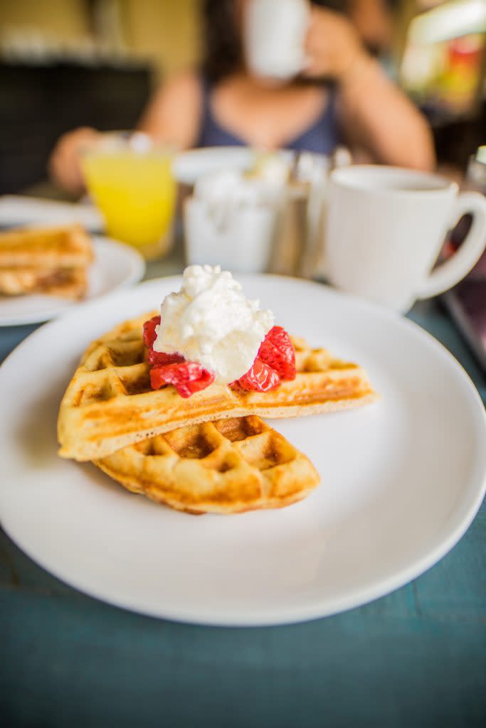 Two waffles with berries and cream