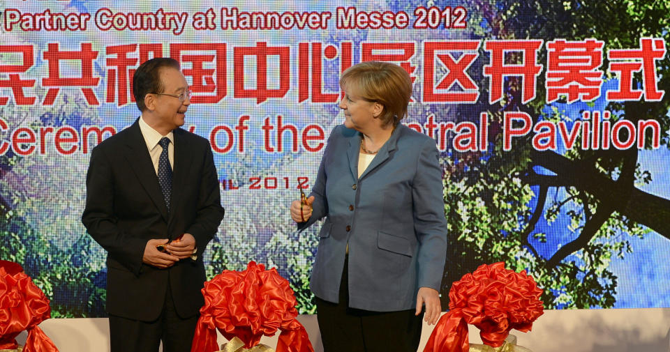 German Chancellor Angela Merkel, right, and Chinese Prime Minister Wen Jiabao cut red ribbons during the opening ceremony of the Hannover industrial fair in Hannover, Germany, Monday, April 23, 2012. This year's partner country of the fair, with about 5,000 exhibitors from 69 countries, is China. (AP Photo/dapd, Nigel Treblin)