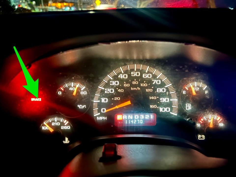 Dashboard with arrow pointing to the brake light, which is on