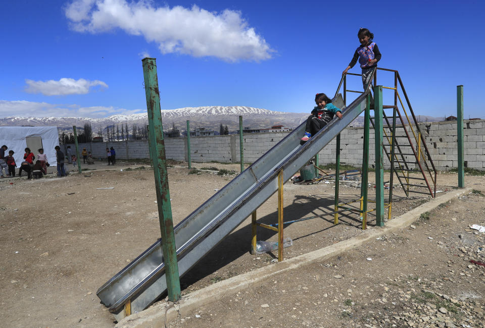 Displaced Syrian girls play on a slide, at a refugee camp in Bar Elias, Bekaa Valley, Lebanon, Friday, March 5, 2021. UNICEF said Wednesday, March 10, 2021 that Syria’s 10-year-long civil war has killed or wounded about 12,000 children and left millions out of school in what could have repercussions for years to come in the country. The country's bitter conflict has killed nearly half a million people, wounded more than a million and displaced half the country’s population, including more than 5 million as refugees. (AP Photo/Hussein Malla)