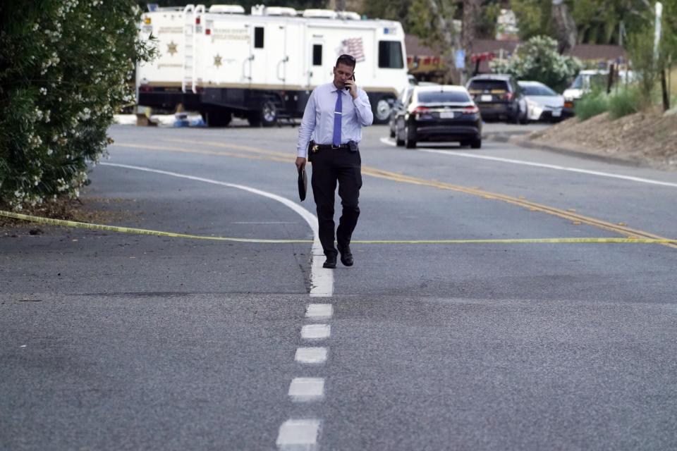 A detective walks at the scene of a mass shooting at Cook's Corner, Thursday, Aug. 24, 2023, in Trabuco Canyon, Calif. (AP Photo/Damian Dovarganes)