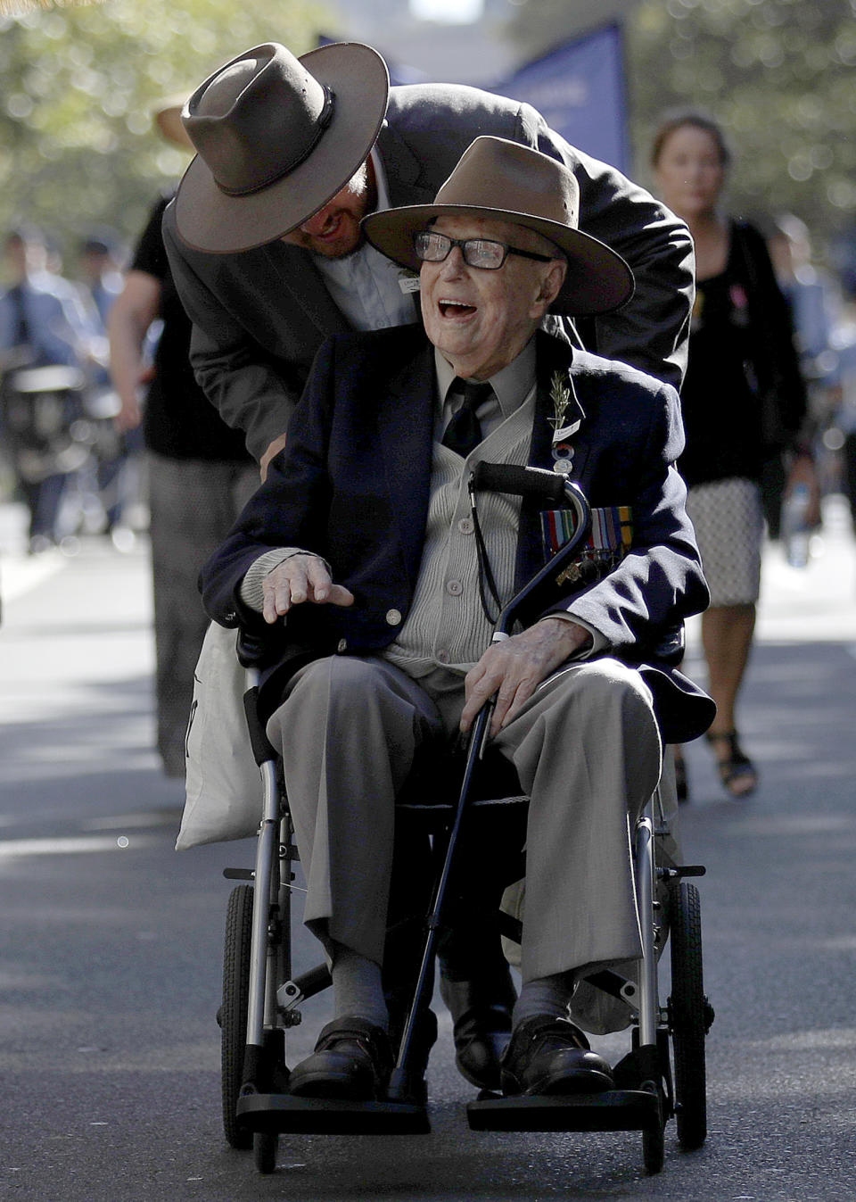 World War II veteran 103-year-old Bert Collins is pushed in his wheelchair during a march celebrating ANZAC Day, a national day of remembrance in Australia and New Zealand that commemorates those that served and died in all wars, conflicts, and while peacekeeping, in Sydney, Australia, Thursday, April 25, 2019. (AP Photo/Rick Rycroft)