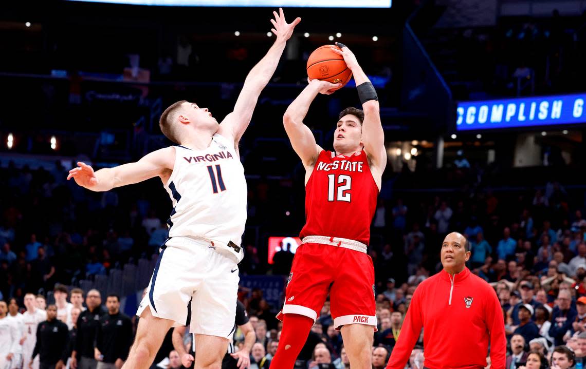 N.C. State’s Michael O’Connell (12) makes a three-pointer as time expires to tie the game in regulation during the Wolfpack’s 72-65 overtime victory over Virginia in the semifinals of the 2024 ACC Men’s Basketball Tournament at Capital One Arena in Washington, D.C., Friday, March 15, 2024. Virginia’s Isaac McKneely (11) defends. Ethan Hyman/ehyman@newsobserver.com